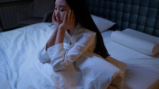 woman sitting up in bed with insomnia