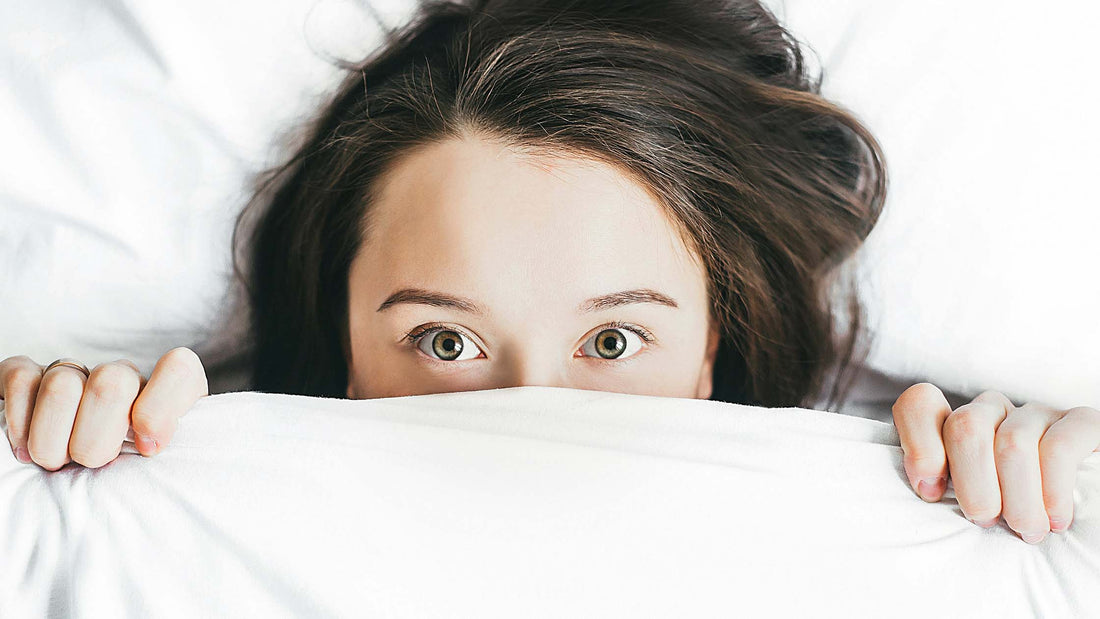 Woman covering her face with blanket